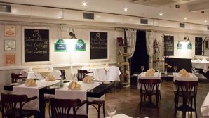 A restaurant interior with tables set for dining, menus on the walls, and a modern, clean design. - Optima Collection Kharkiv Hotel (Kharkiv)
