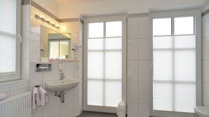 Un baño moderno con lavabo, espejo e inodoro.