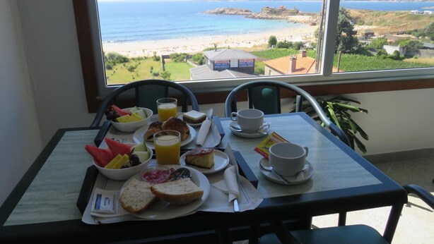 Una mesa de desayuno con vista a la playa y al océano.