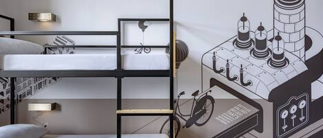 Habitación con literas y un mural en la pared que muestra una bicicleta y una torre.