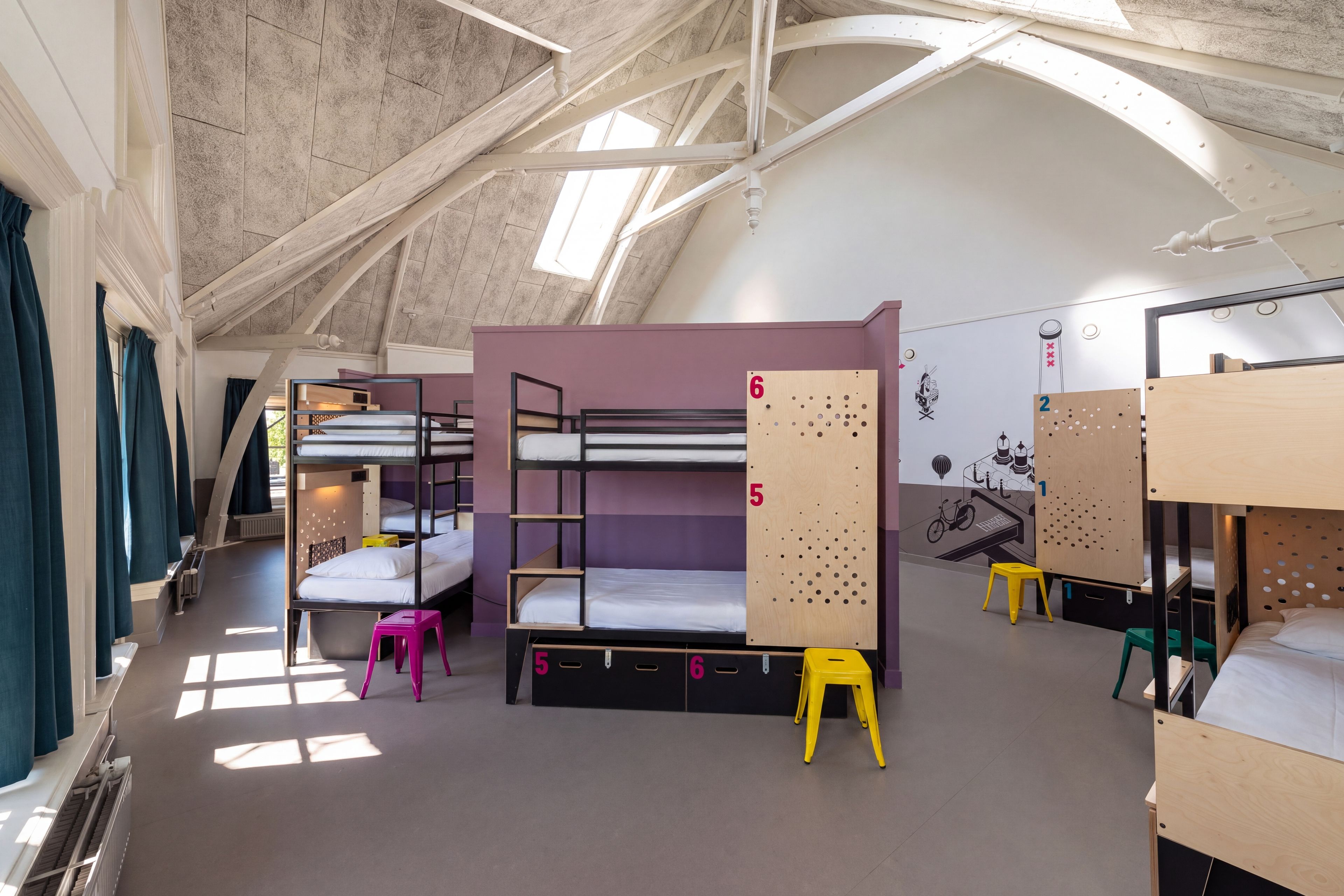 Un dormitorio con literas, un taburete pequeño y una pared con paneles numerados.