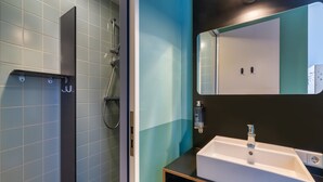 Un baño moderno con ducha, lavabo y espejo.