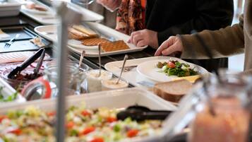 A buffet with various food items and utensils.