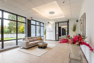 Uma sala espaçosa com sofá, mesa de centro e uma janela ampla com vista para o exterior.