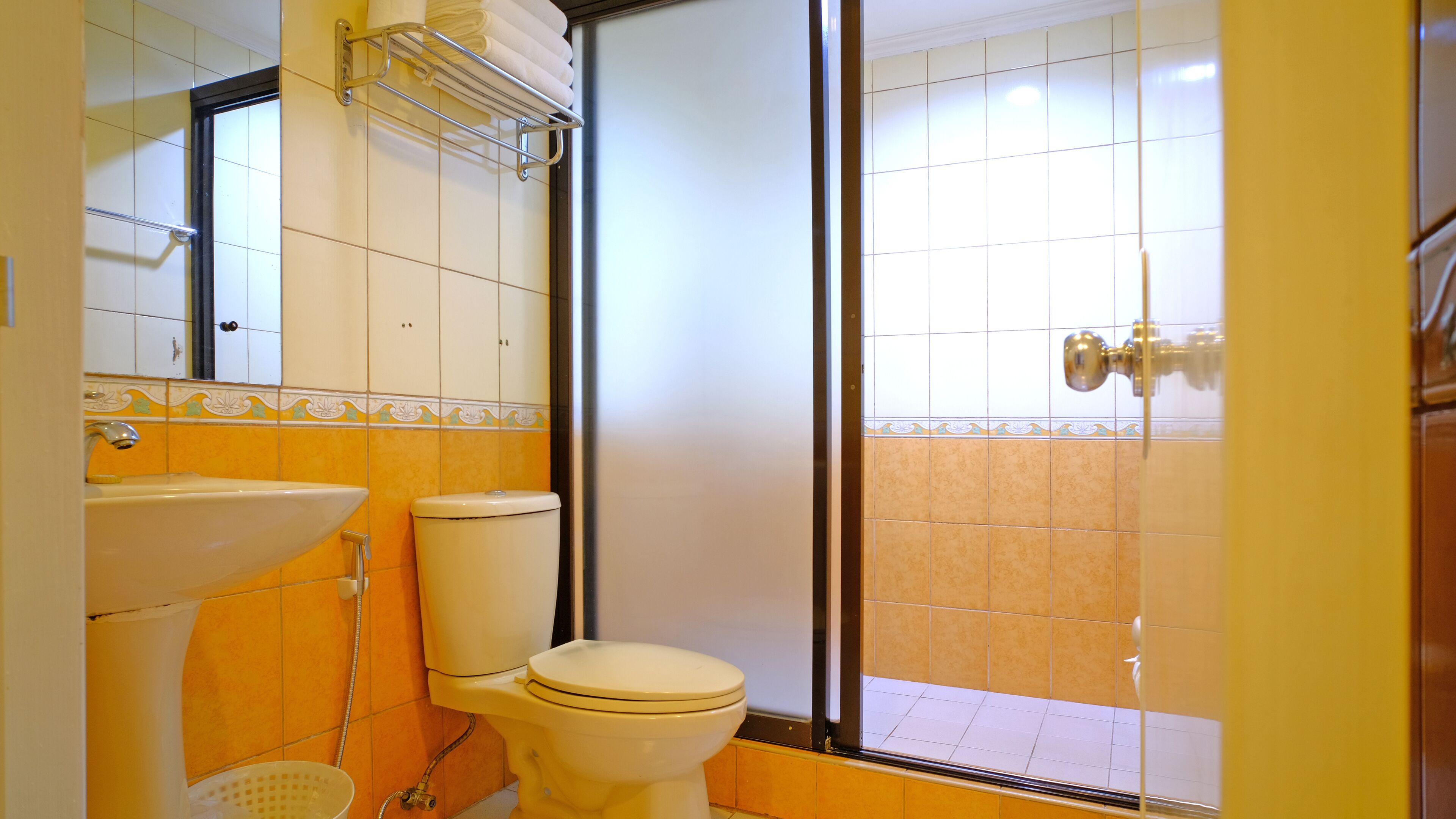 A bathroom with a toilet, sink, and shower area.