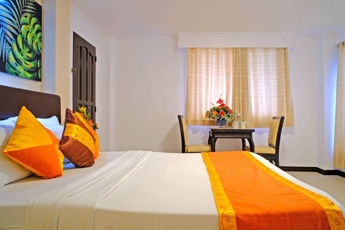 Una habitación de hotel con una cama, un escritorio y una silla.