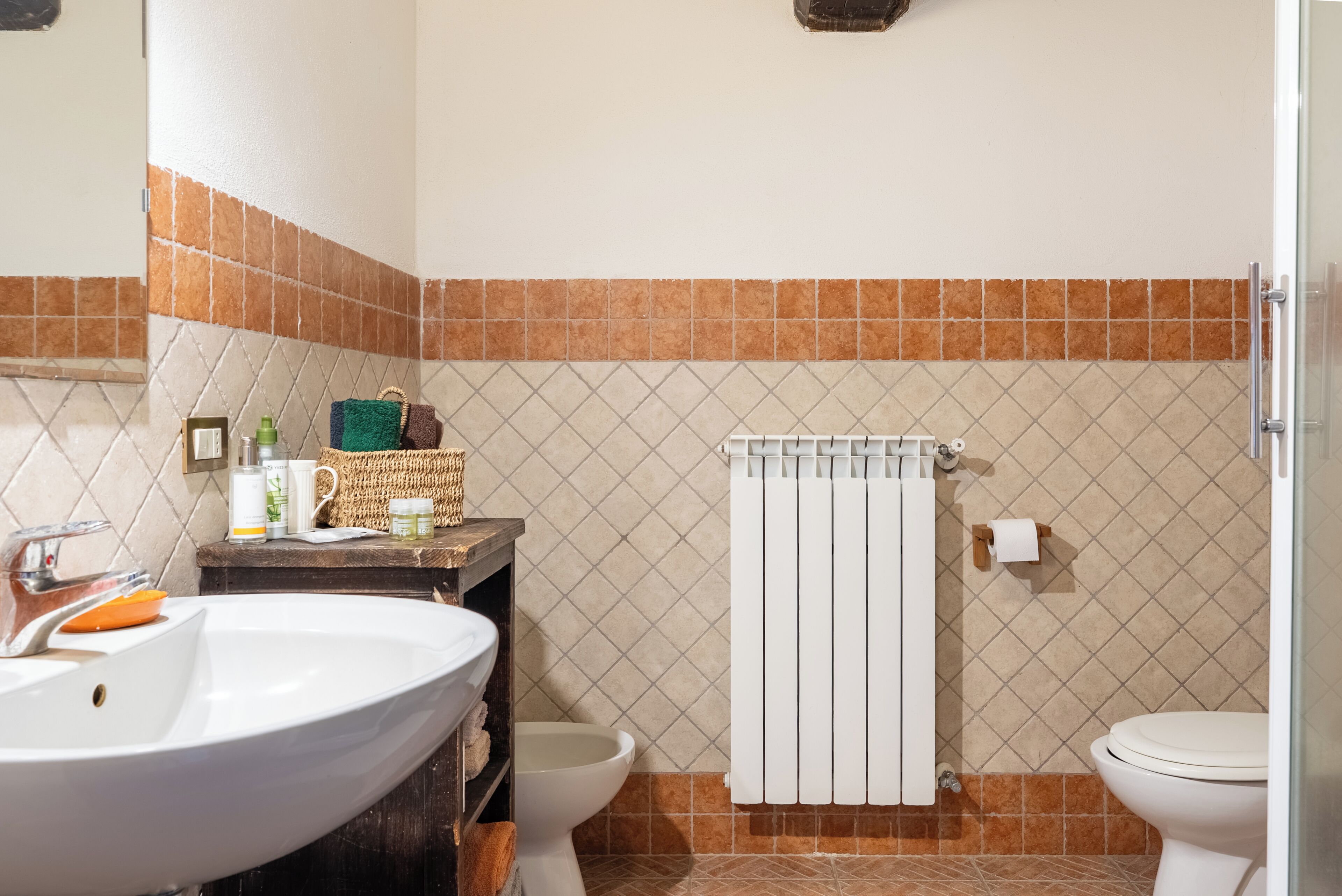 A bathroom with a sink, toilet, and towel rack.