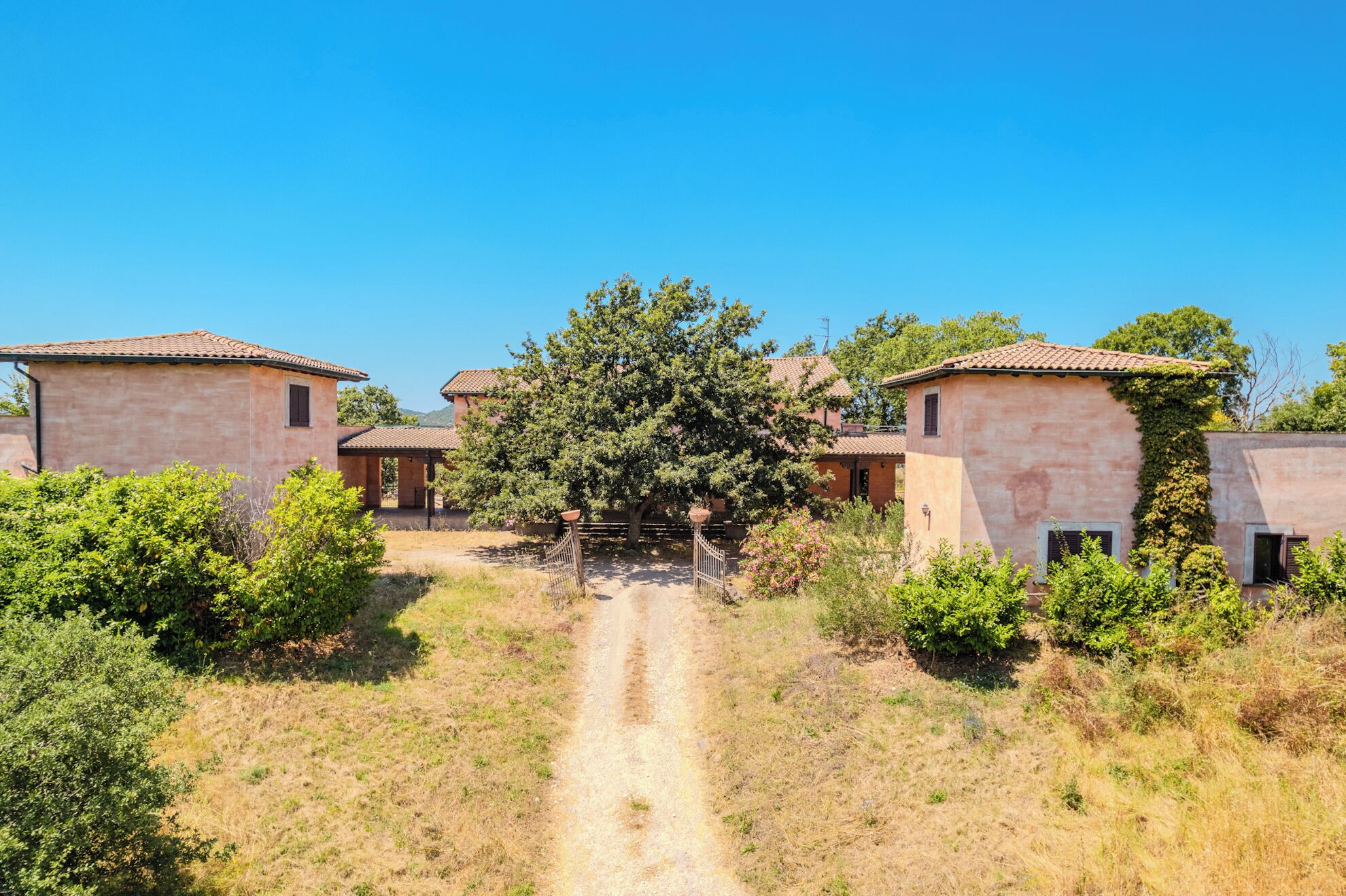 Um cenário rural com uma trilha de terra que leva a uma fileira de edifícios tradicionais com telhados de cerâmica.