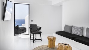 Una sala de estar moderna con un sofá negro, una mesa de centro de madera y una silla negra.