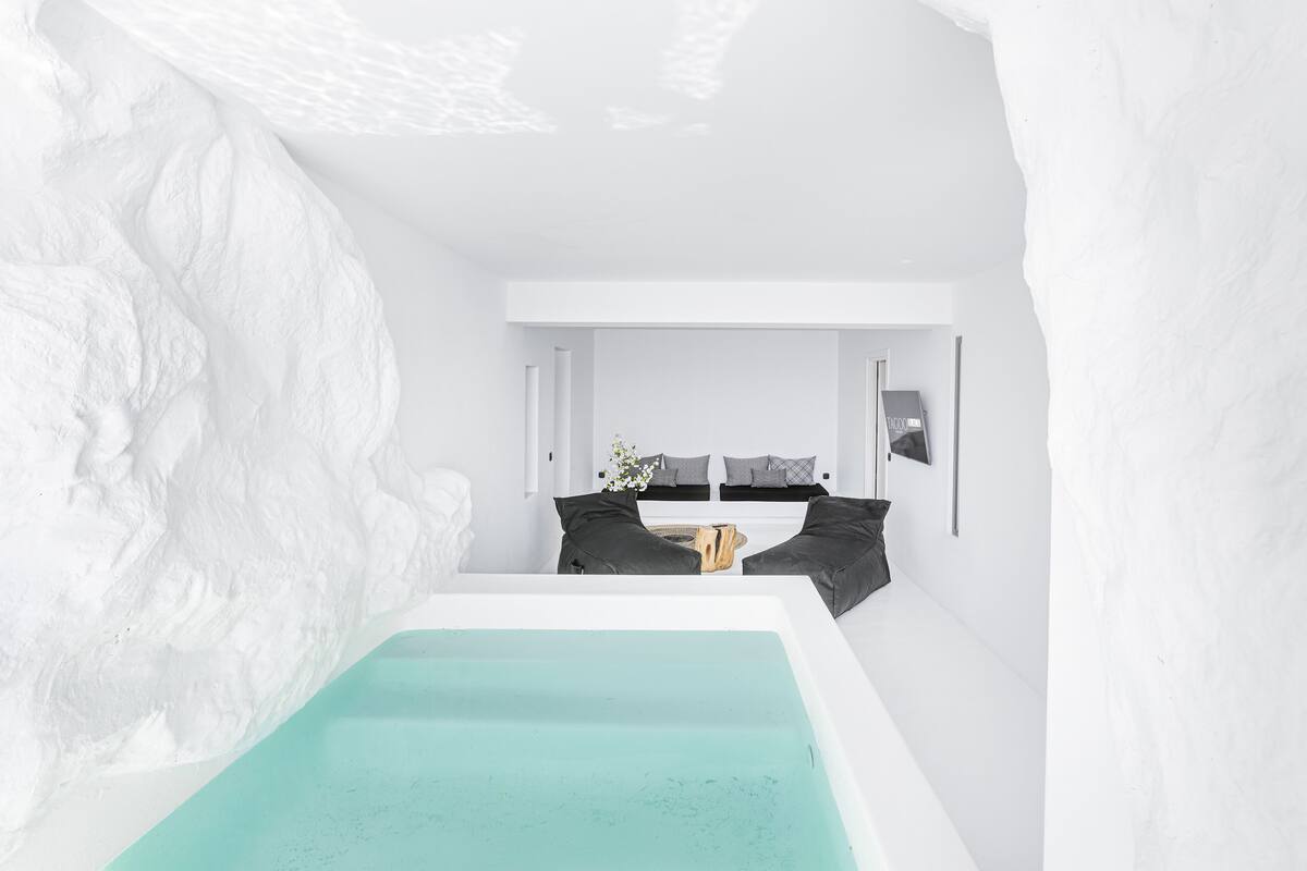 Un baño moderno y minimalista con una bañera grande, paredes blancas y una paleta de colores neutros.