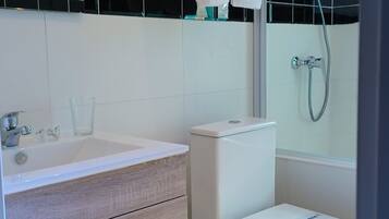 Un baño moderno con inodoro, lavabo y ducha.