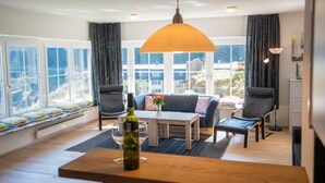 A modern living room with a sofa, chairs, a coffee table, and a large window. - Alpenhof (Bad Gastein)