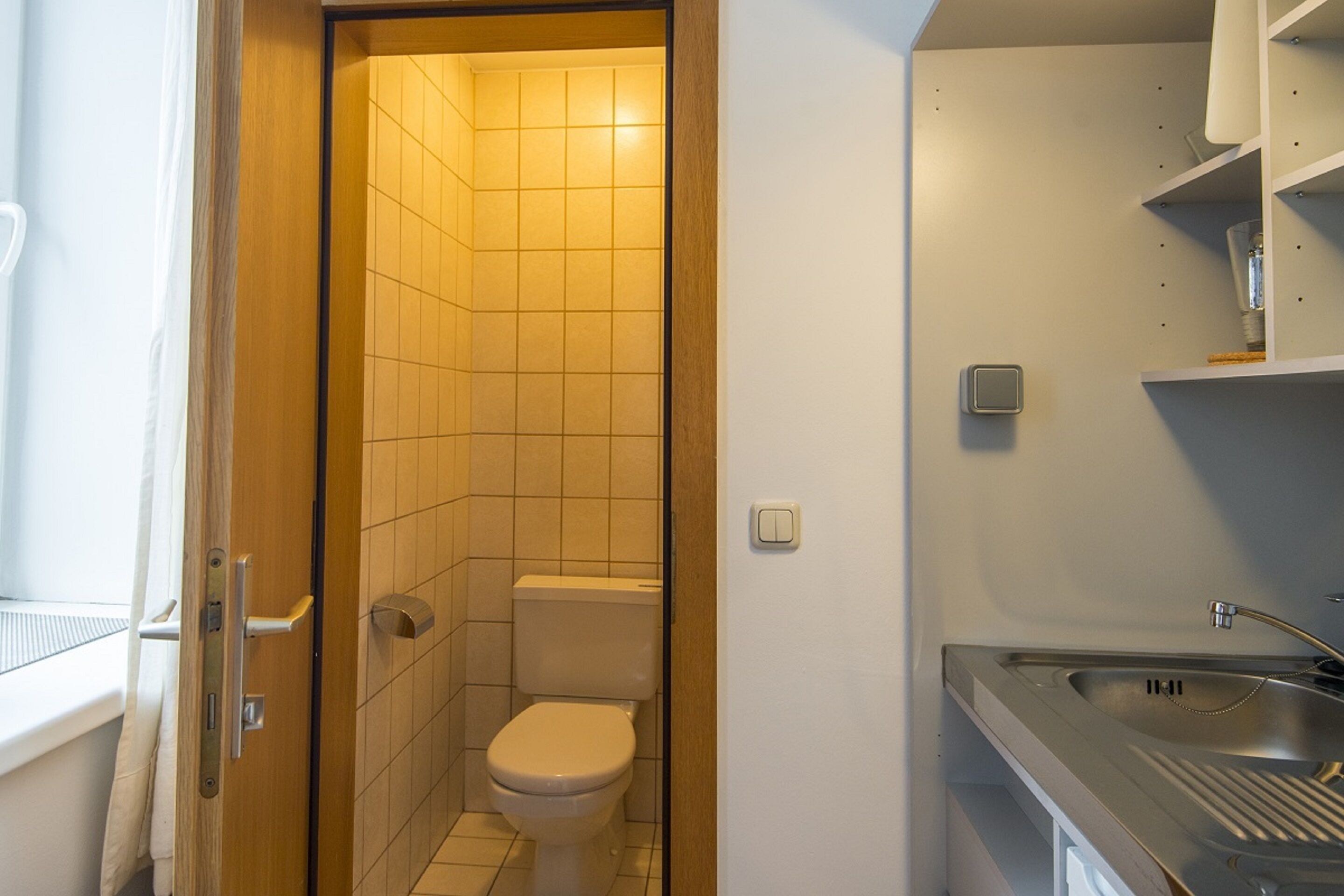 Un baño pequeño con inodoro, lavamanos y zona de ducha.