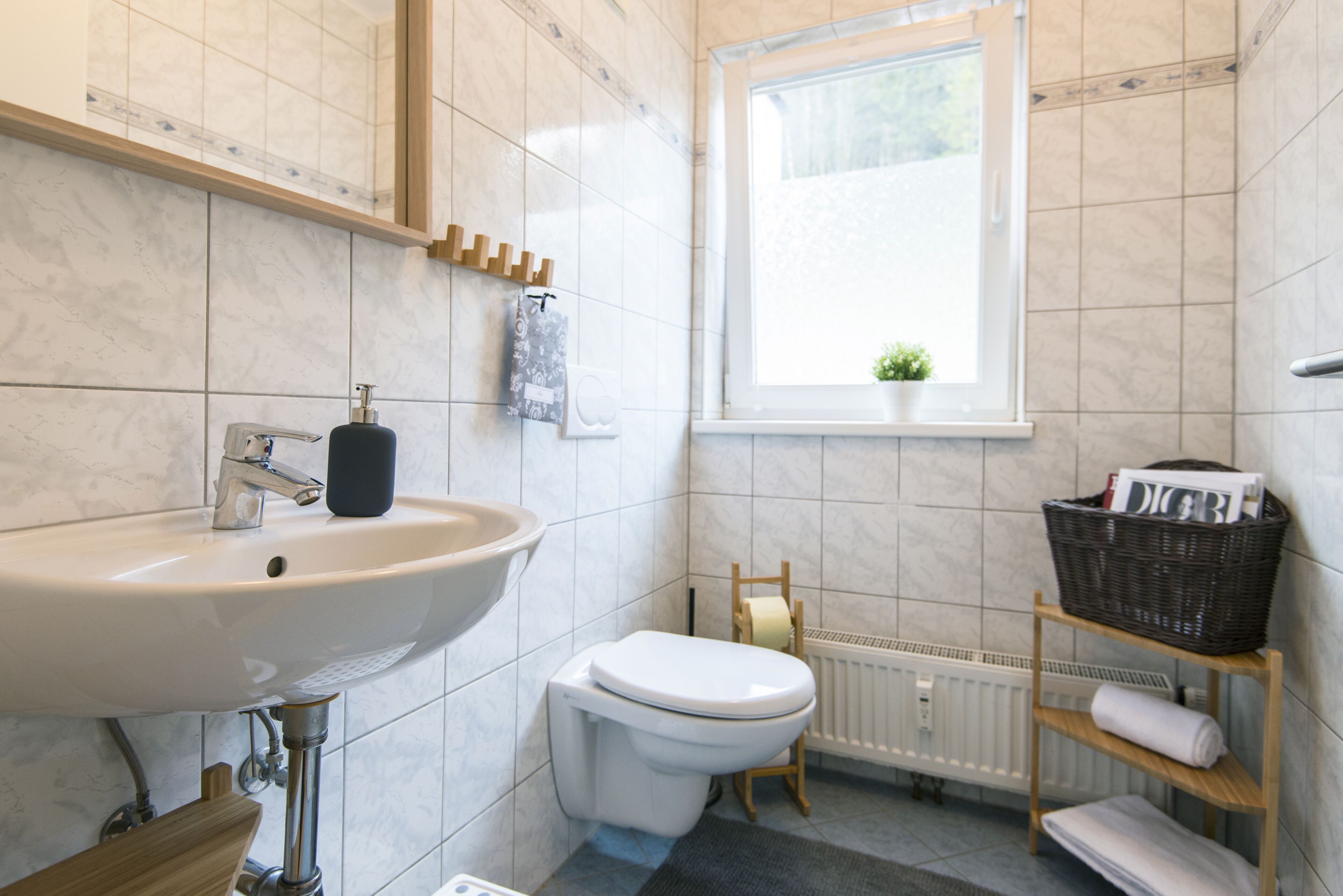 Ein Badezimmer mit Waschbecken, Toilette und Fenster.