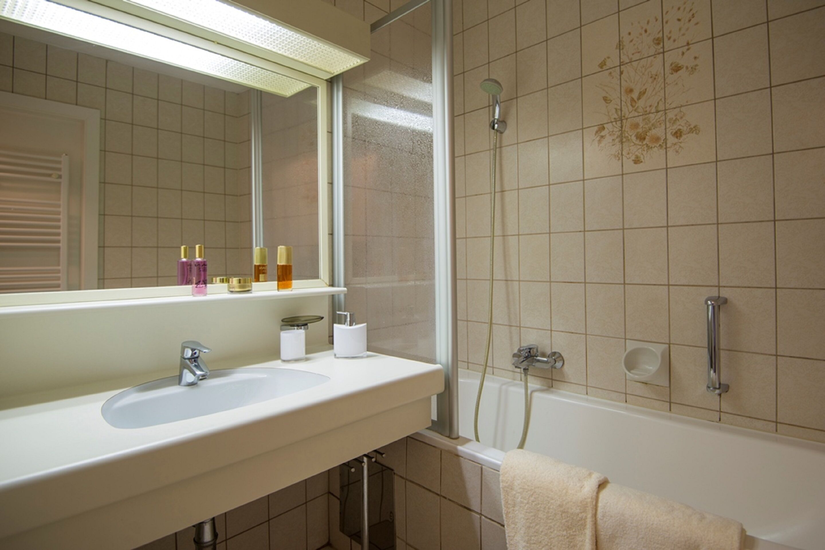 Un baño con lavabo, espejo y ducha.