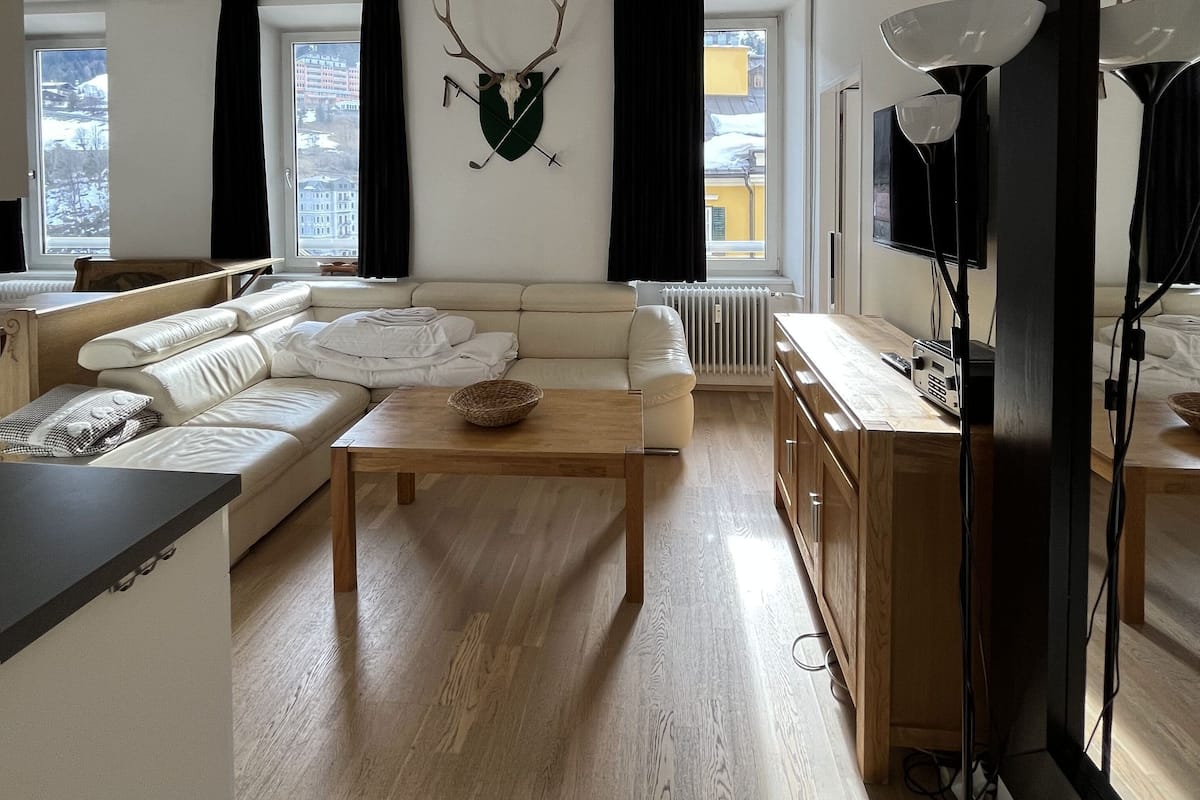 A modern living room with a sofa, a coffee table, and a mounted deer head.