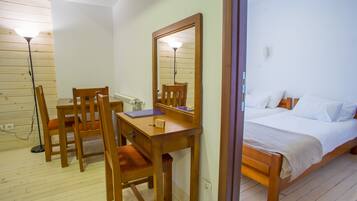 Un dormitorio con una cama de madera, una mesita de noche, una silla y un escritorio con espejo.