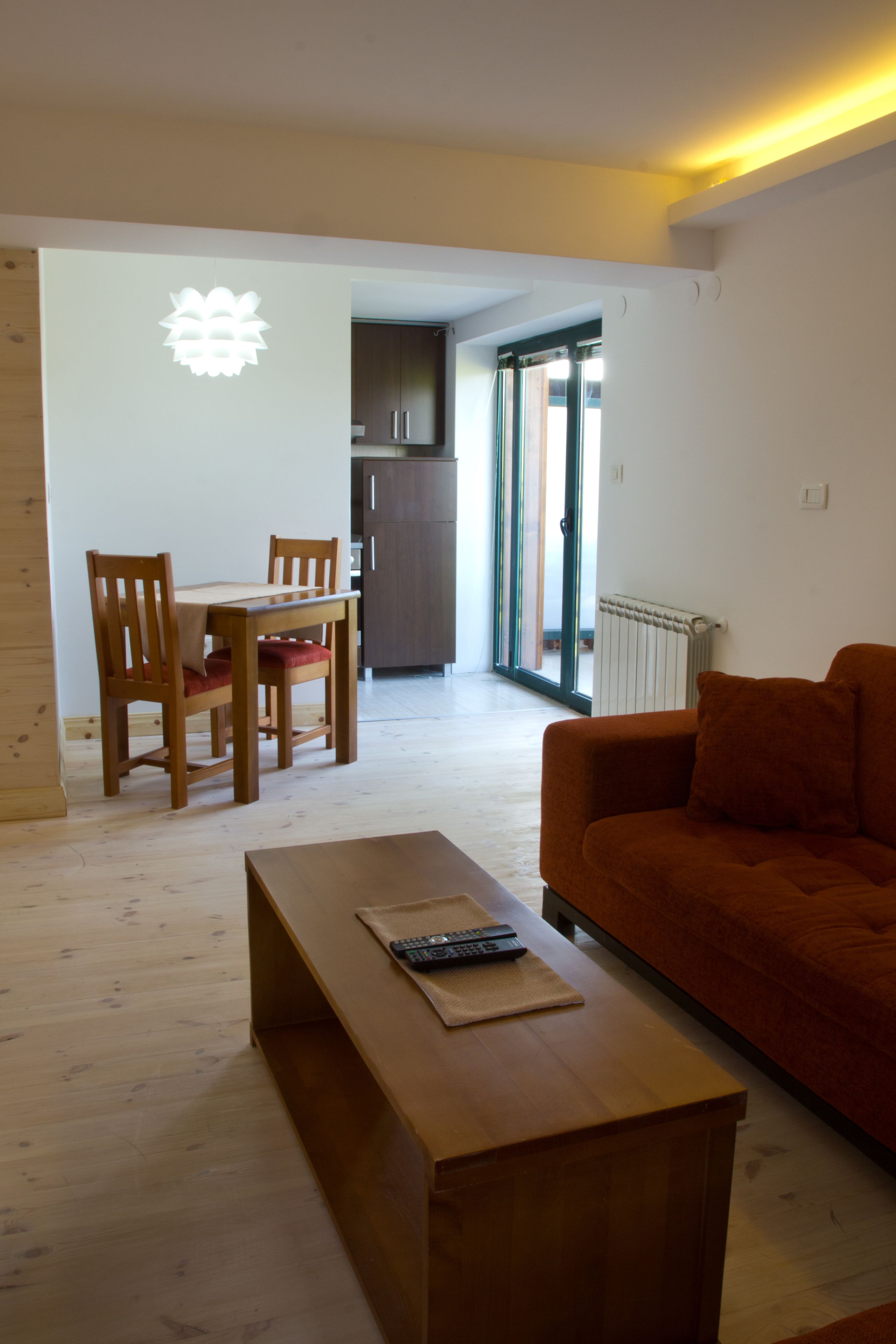 Una sala de estar con un sofá, una mesa de centro de madera y un comedor con mesa y sillas.