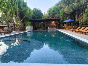 Una piscina al aire libre, cabañas de piscina gratuitas, sombrillas