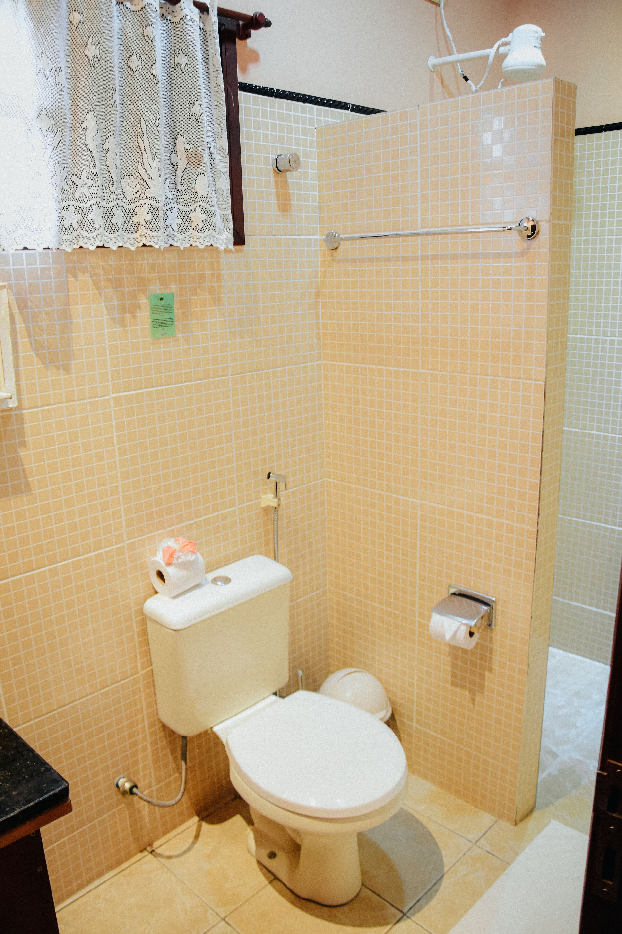 A bathroom with a toilet, a shower, and a sink.