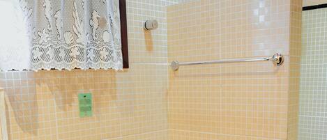 A bathroom with a toilet, a shower, and a sink.