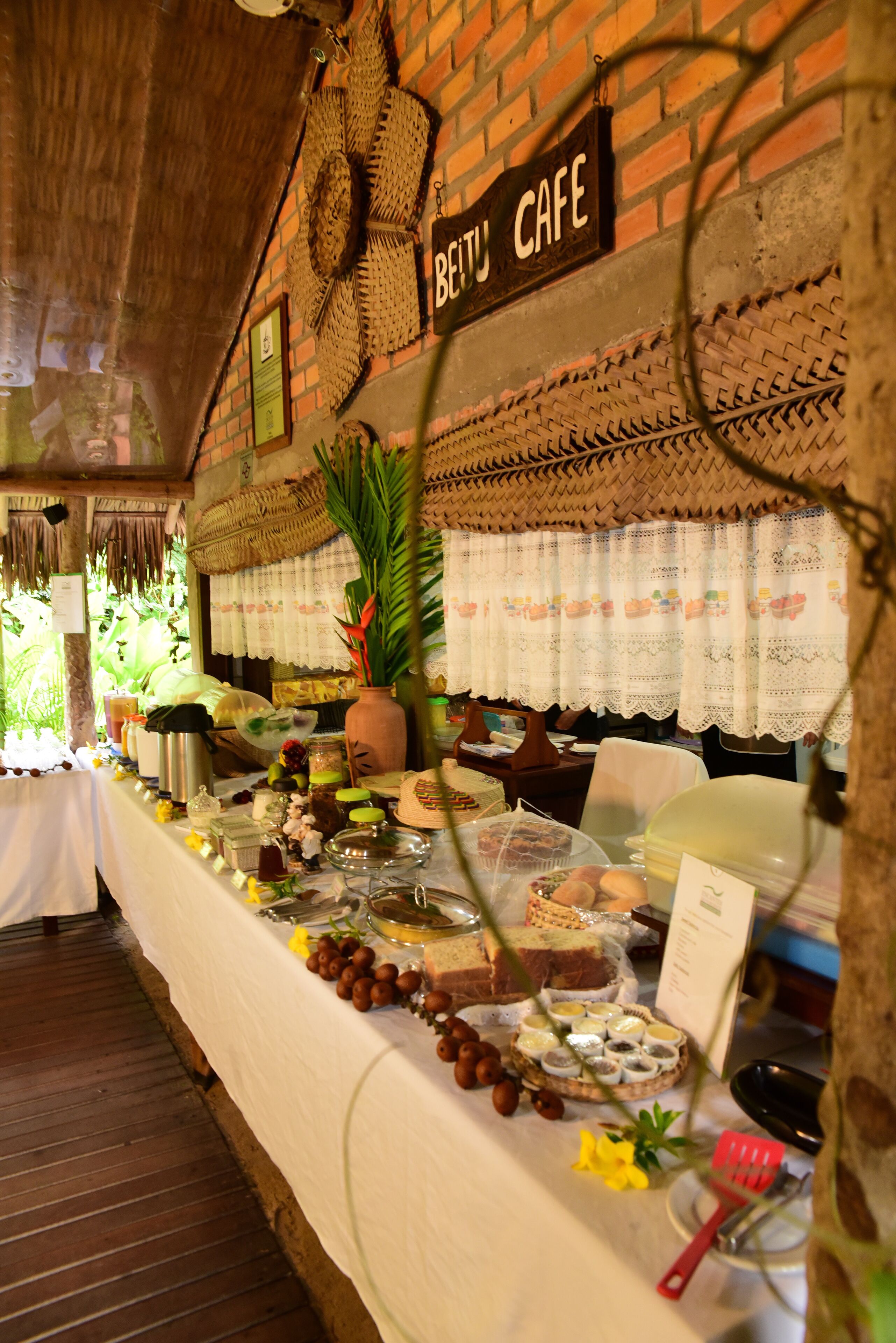 Une table de buffet proposant divers plats et une pancarte sur laquelle on peut lire « BETTU CAFE ».