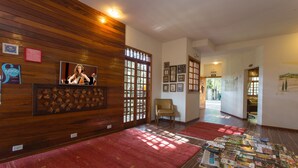 A hotel lobby with wooden paneling, a red carpet, and a display of books. - Pousada La Toscana (Campos do Jordão)