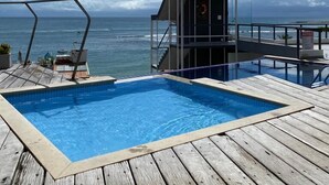 A wooden deck with a swimming pool and a lifeguard tower overlooking the ocean. - Pousada Ilha da Saudade (Cairu)