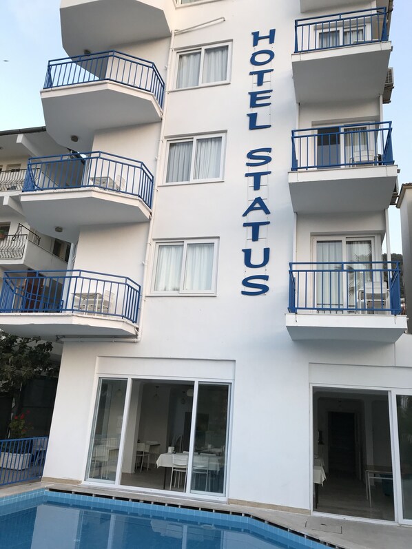 A hotel building with multiple balconies, large windows, and a swimming pool. - Status Hotel (Fethiye)