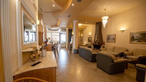A spacious living area with a kitchen, dining area, and a large sofa set. - Hotel Kaikis (Kalabaka)