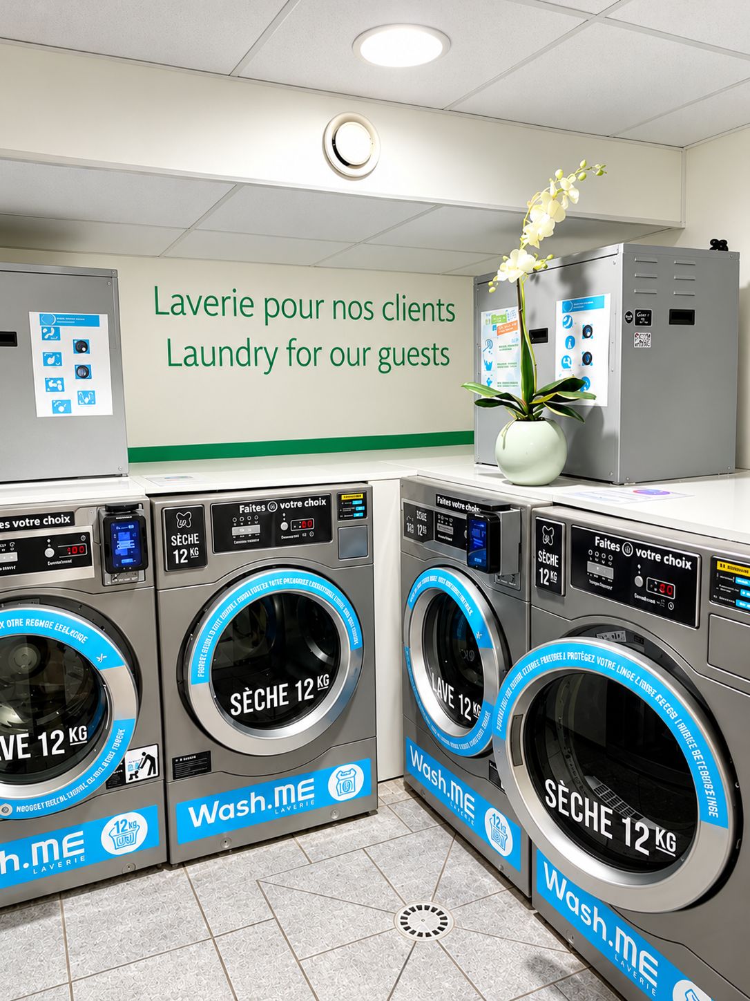 A laundry facility with multiple washing machines, each labeled 'Wash.me' and 'SÈCHE 12 KG'.