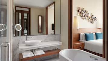 A modern bathroom with a marble sink, a freestanding bathtub, and a wooden vanity.