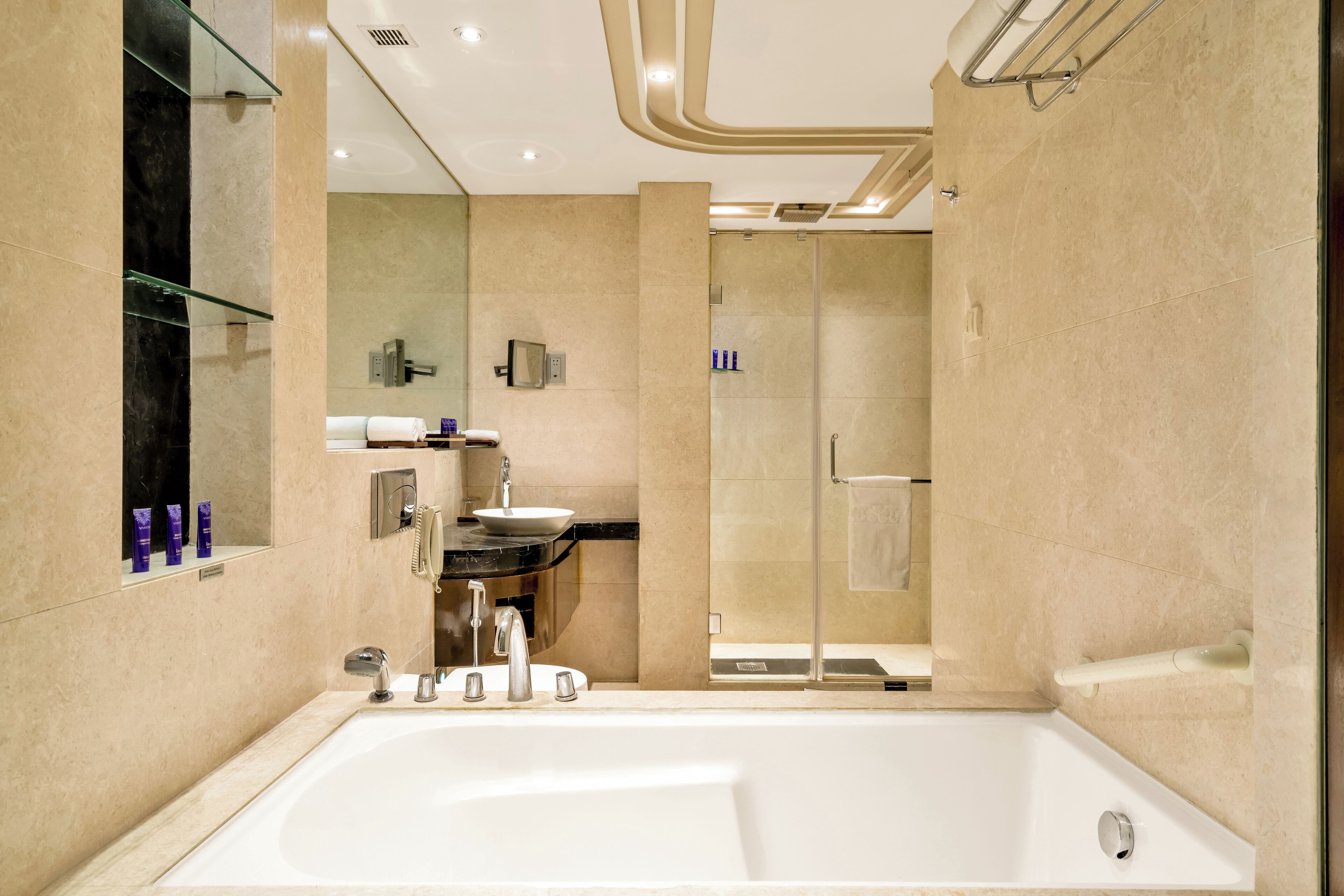 Une salle de bain moderne dotée d’une grande baignoire, d’une douche à parois de verre et d’un meuble-lavabo avec un évier et un miroir.