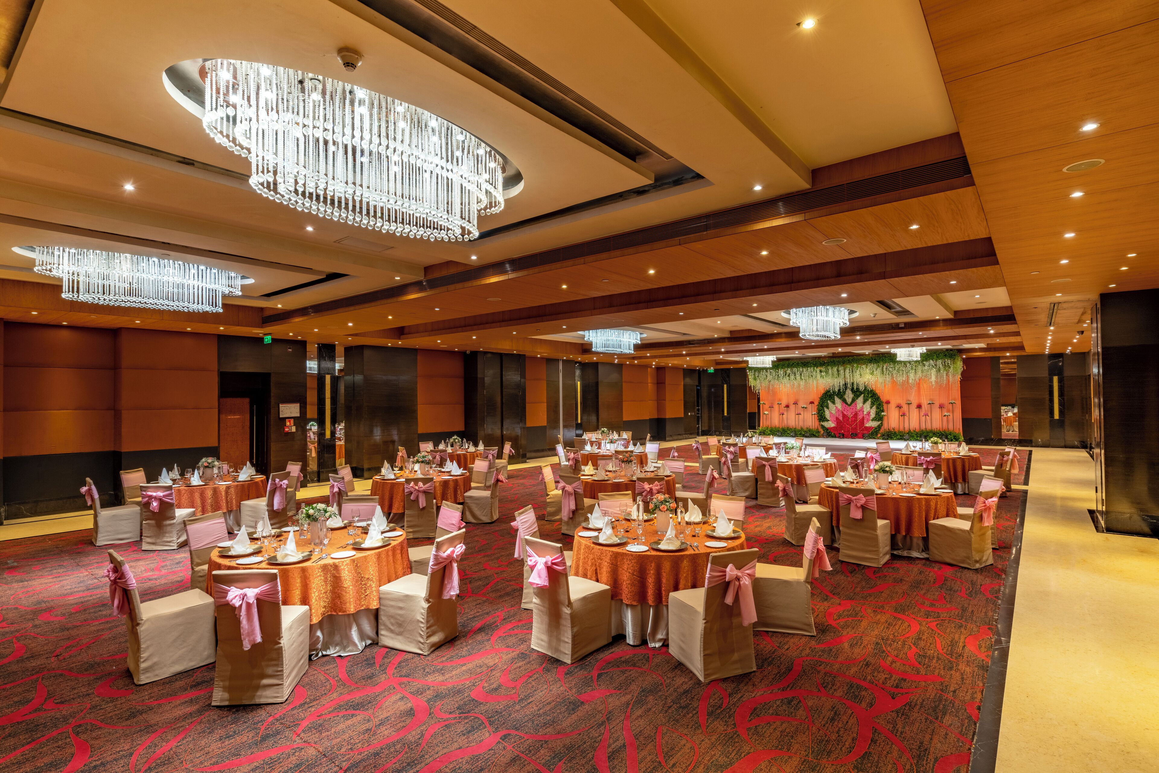 Une salle de banquet avec des tables rondes, des chaises et des lustres.