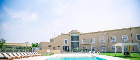 Una piscina techada, una piscina al aire libre de temporada, sombrillas