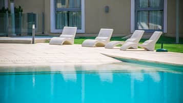 Una piscina techada, una piscina al aire libre de temporada, sombrillas