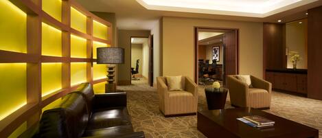 A lobby with a patterned carpet, leather sofas, and armchairs.