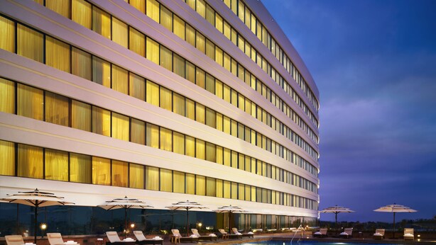 A hotel with a large pool, sun loungers, and umbrellas. - Vivanta Coimbatore (Coimbatore)