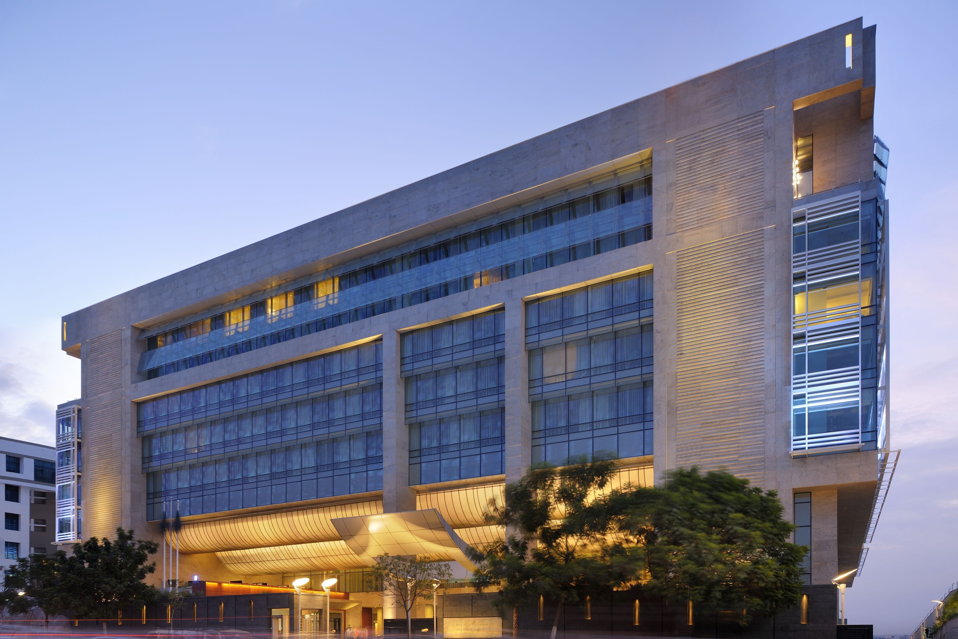 A modern building with multiple floors, large windows, and a prominent entrance with a curved roof.