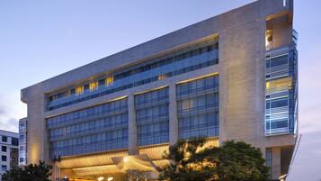 A modern building with multiple floors, large windows, and a prominent entrance with a curved roof.