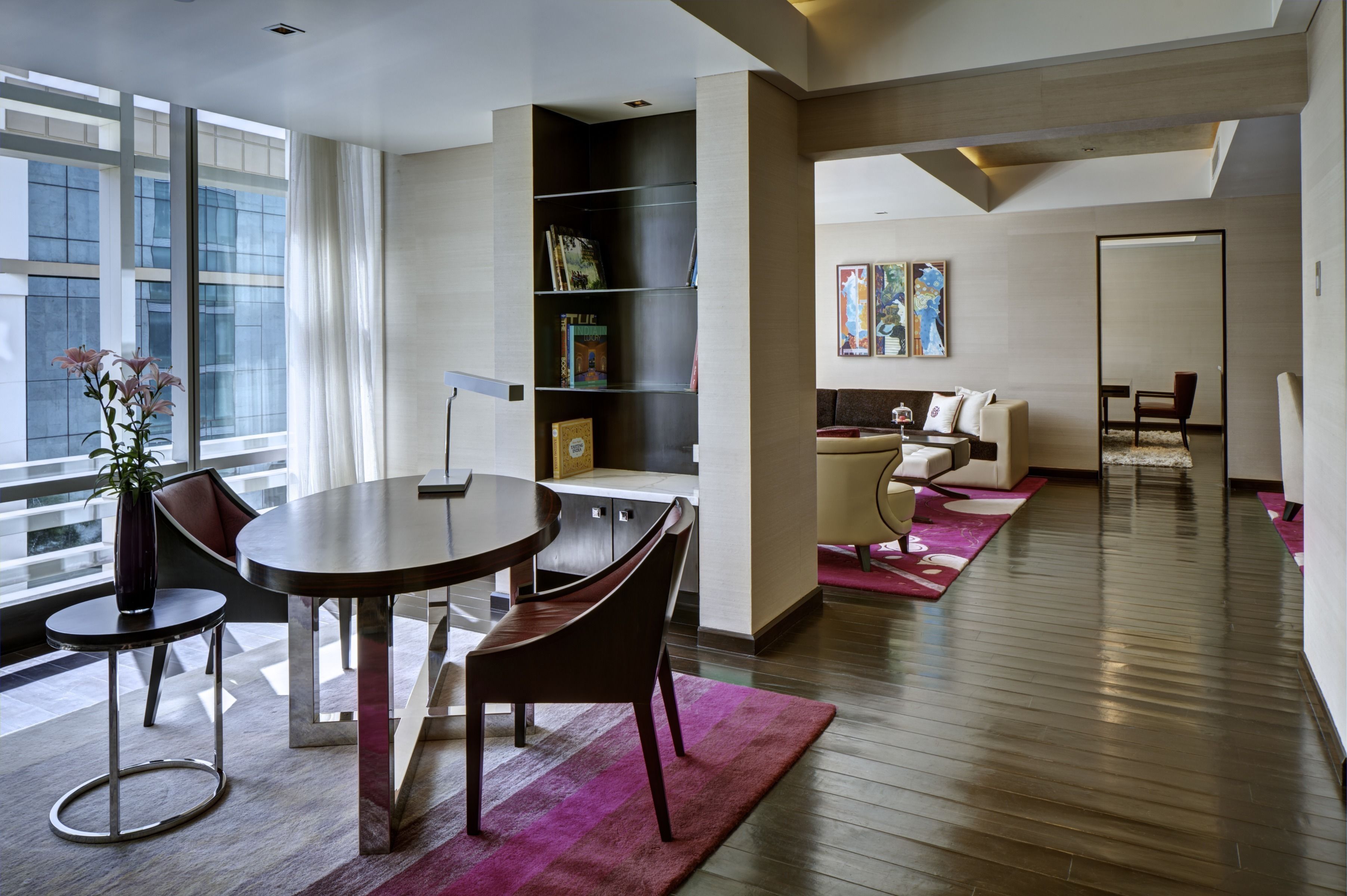 A modern living room with a dining area, a bookshelf, and a sofa.