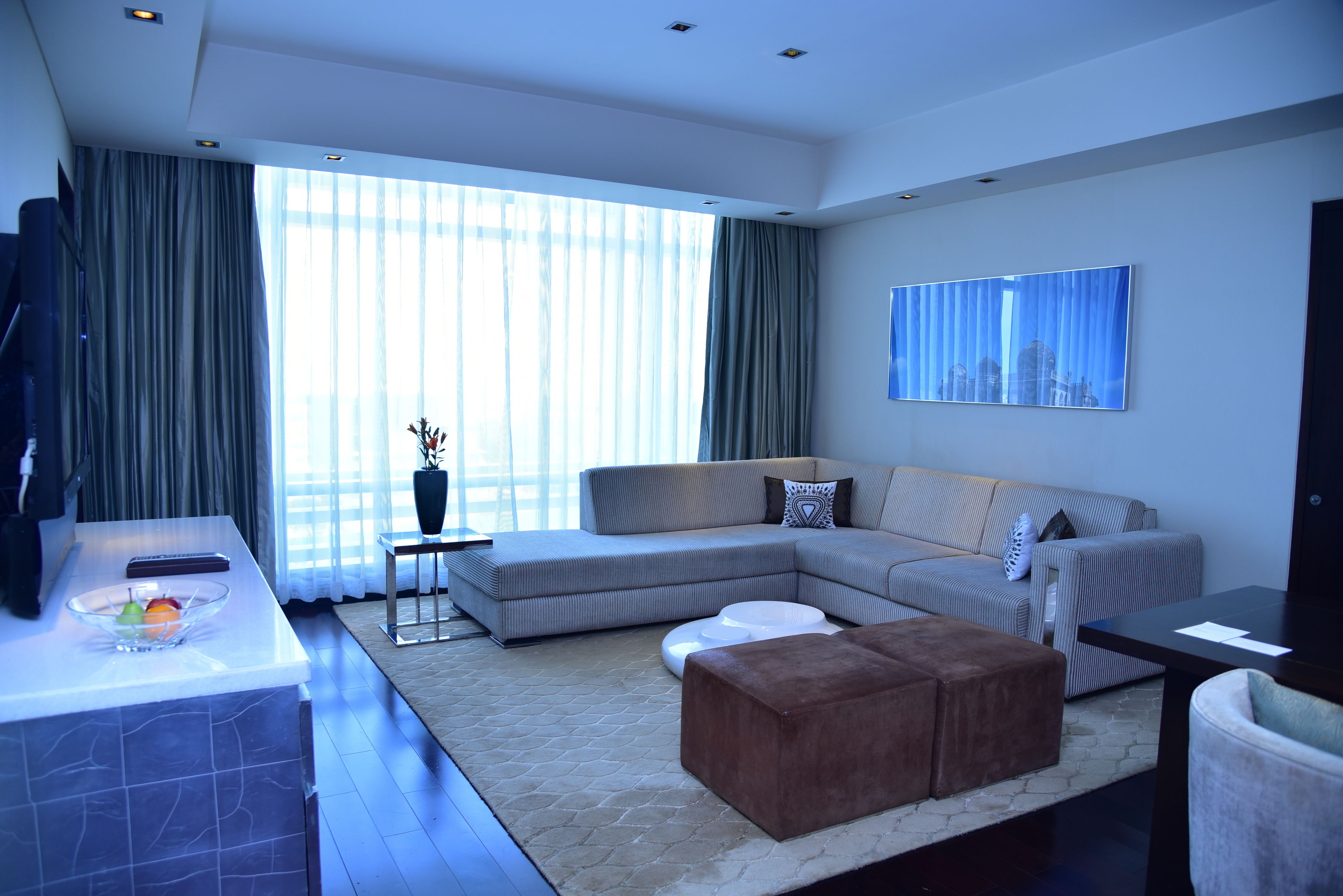 A modern living room with a sectional sofa, a coffee table, and a flat-screen TV.