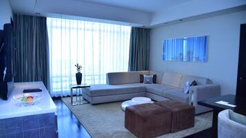 A modern living room with a sectional sofa, a coffee table, and a flat-screen TV.