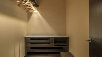 Un pasillo con un banco de madera, una lámpara de pared y una puerta.
