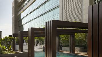 A poolside area with lounge chairs and a view of a building with large windows.