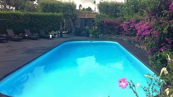 Utomhuspool, parasoller och solstolar