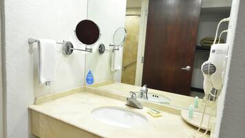 A bathroom with a sink, two mirrors, a towel rack, and a hairdryer.