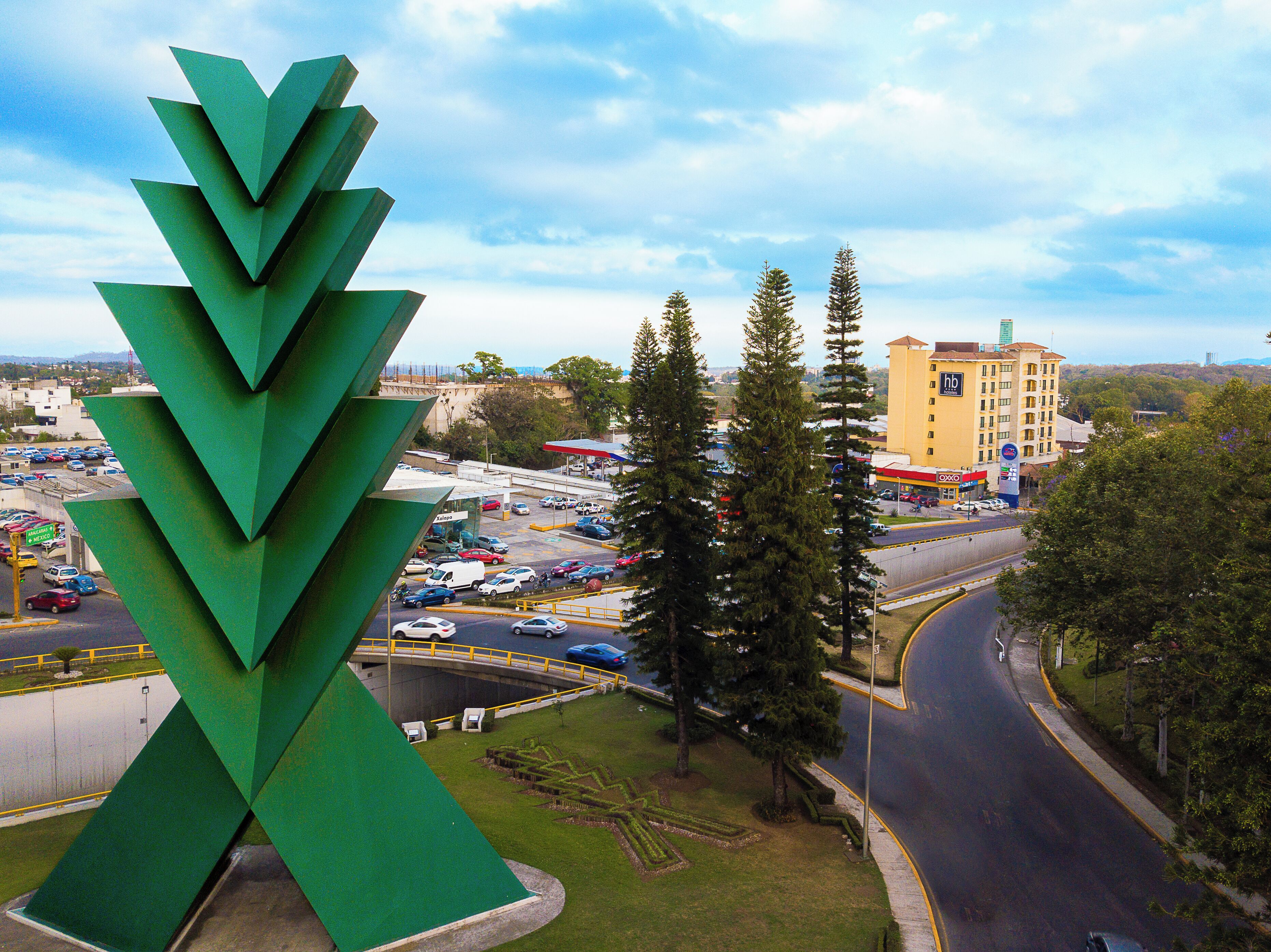 A modern building with a unique green sculpture in front.