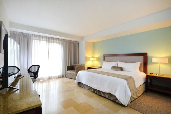 A hotel room with a bed, two chairs, a desk, and a lamp. - HB Xalapa (Xalapa)