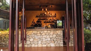 Una zona de bar con mostrador de piedra y estantes llenos de botellas.